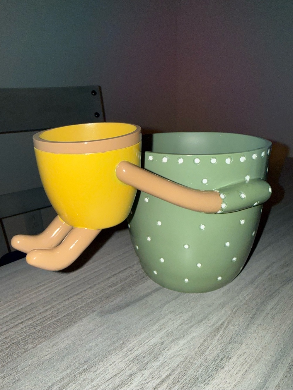 Green Polka Dot and Yellow planters holding each other.